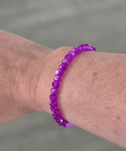 De paarse kralenarmband is geregen op stevig elastiek met facetkralen