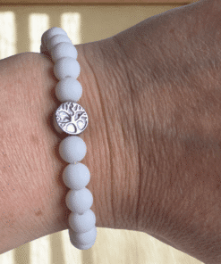 Handgemaakte kralenarmband wit met een goud of zilverkleurige levensboom bedel