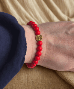 De rode kralenarmband met levensboom is handgemaakt