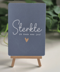 Blauwe kaart met goudfolie tekst sterkte op een houten mini ezel