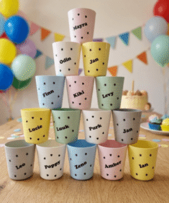 Traktatiebekers met naam op een feestelijke tafel