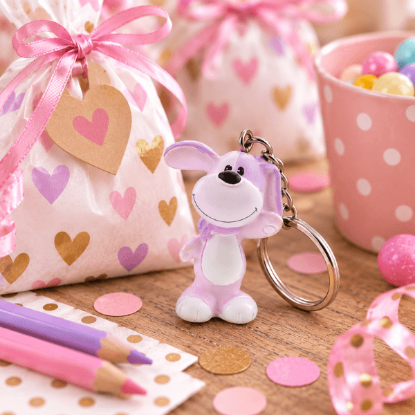 Hondje Toby is een sleutelhanger in lila/roze met een feestelijke achtergrond gemaakt door AI